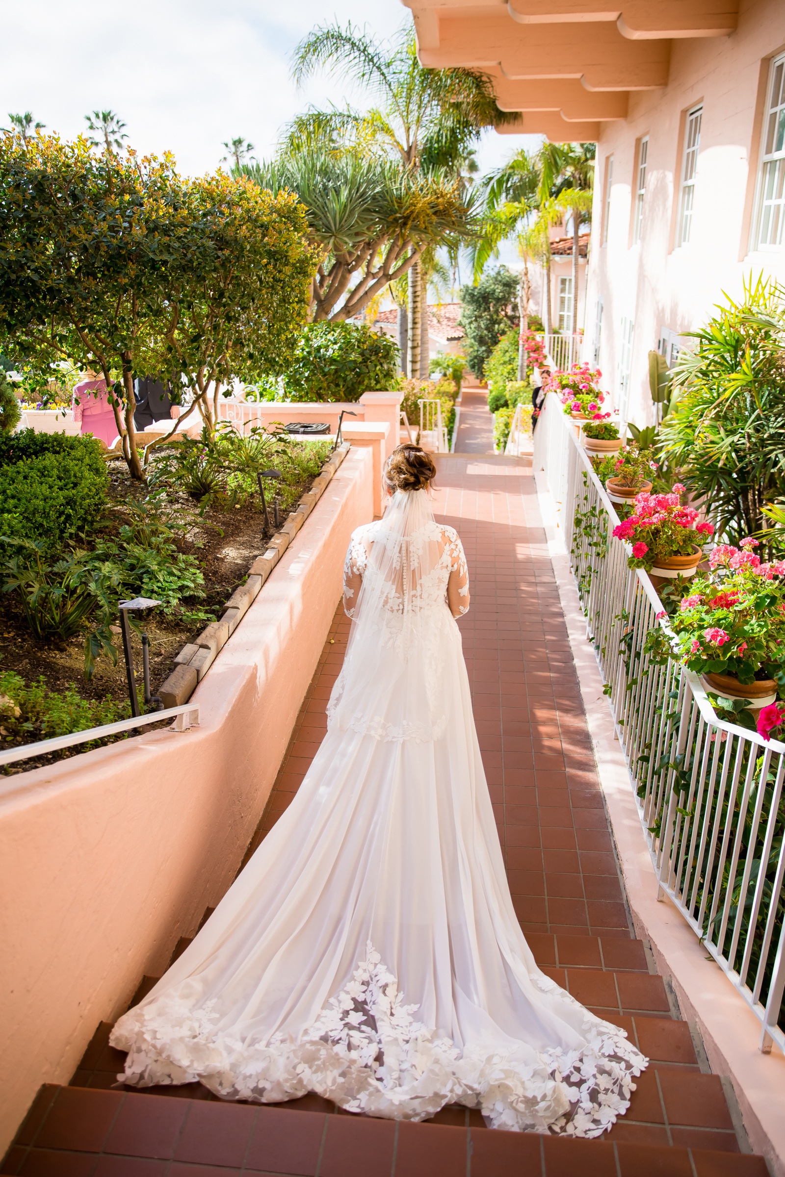 Bride on the pink walkway at La Valencia Hotel with a lace train