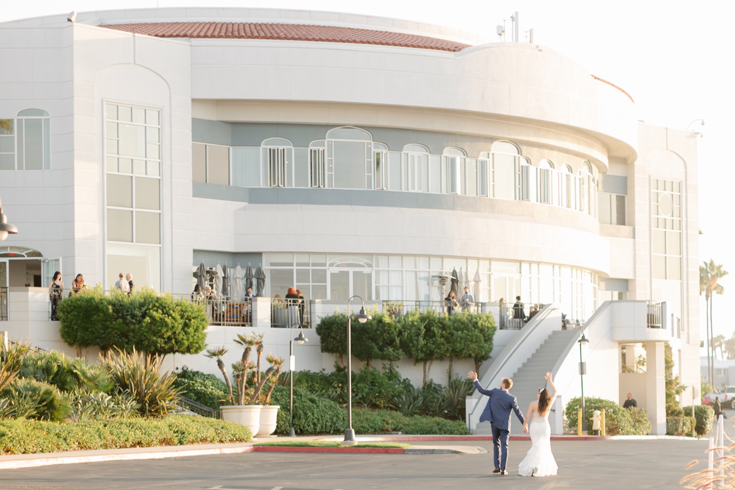 Julianne and David walking toward the resort at Loews Coronado Bay at golden hour