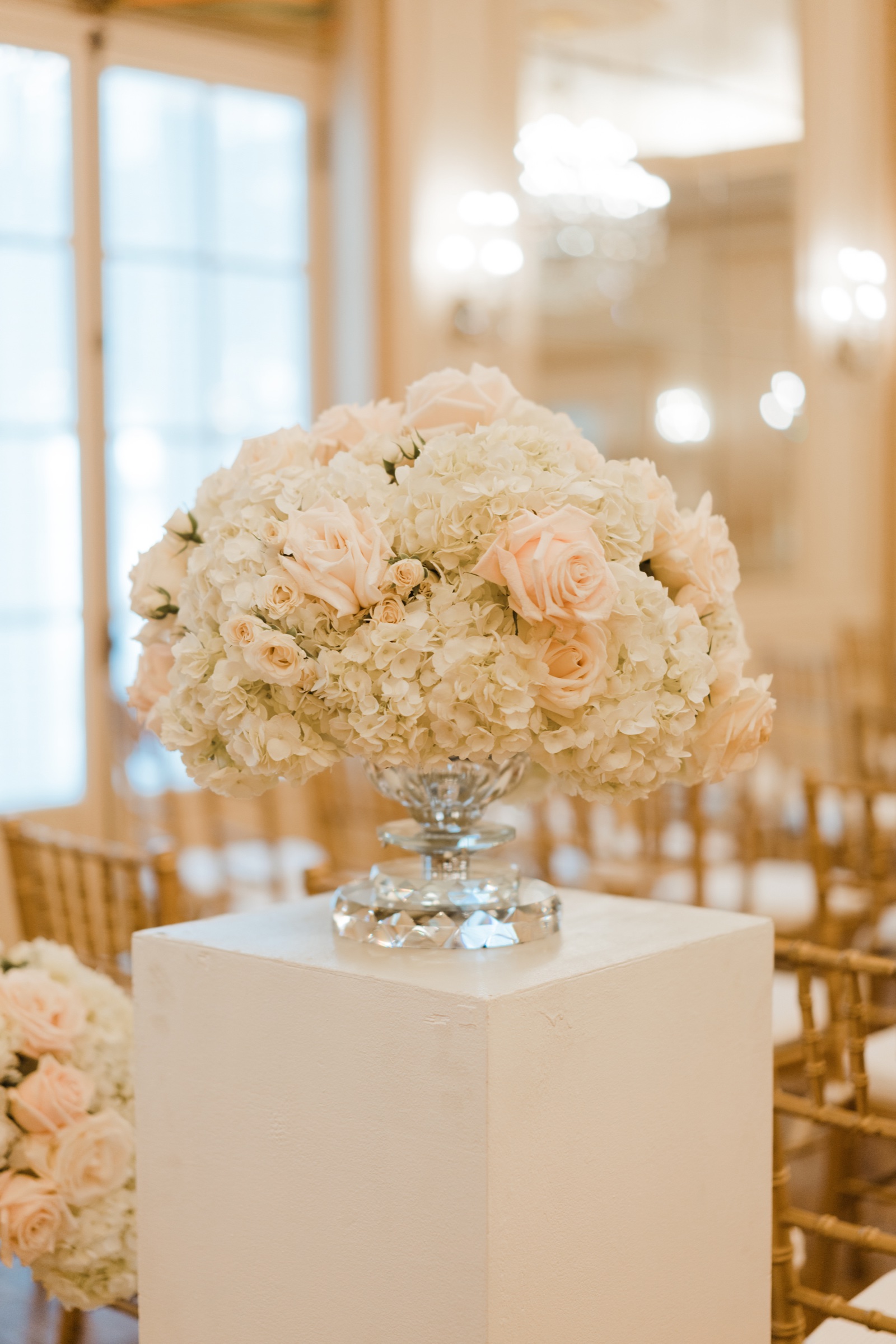 White floral arrangement on a white pedestal for the Sofreh Aghd ceremony