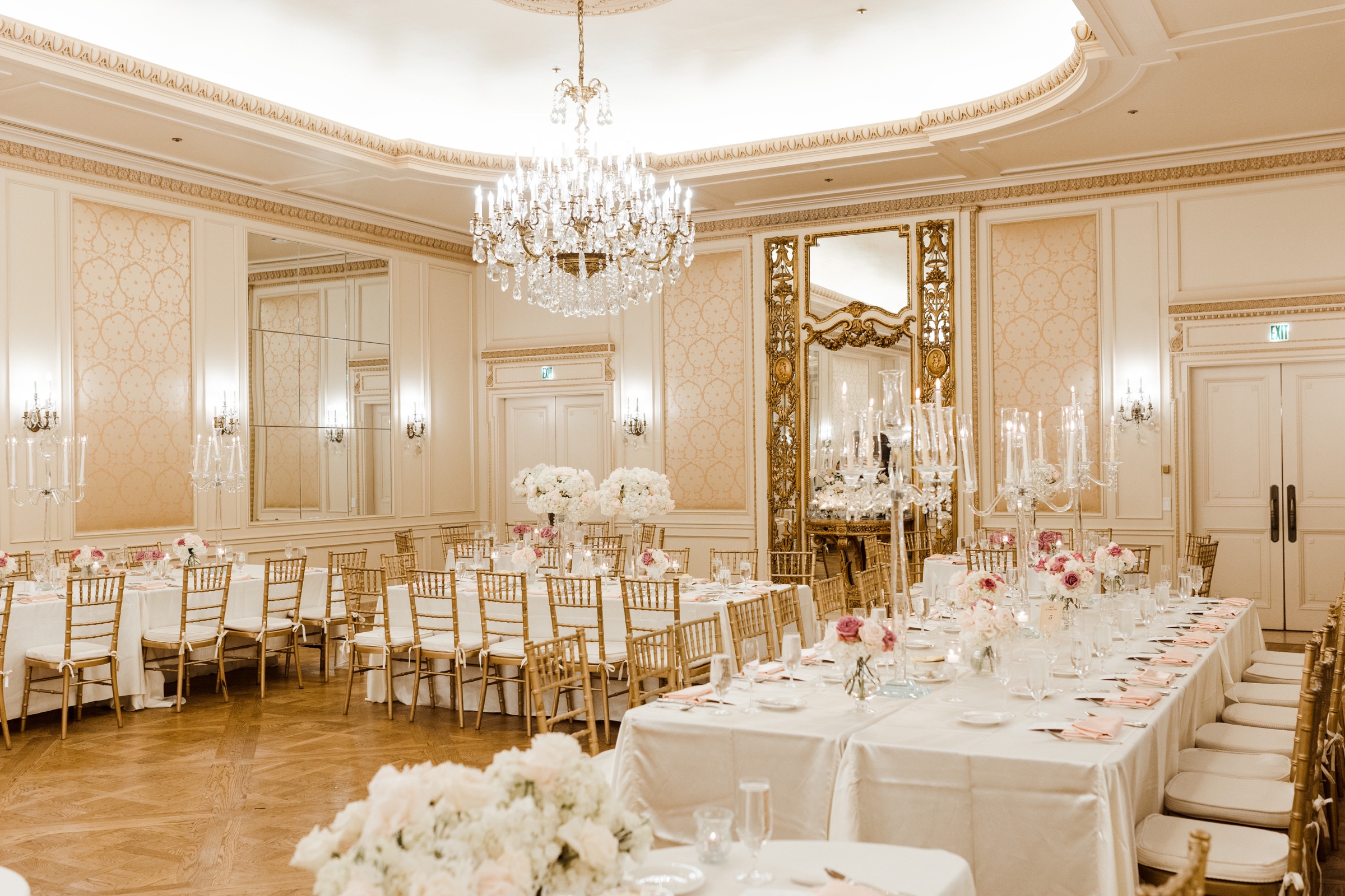 Westgate Hotel ballroom reception with white florals, crystal chandeliers, and gold chairs