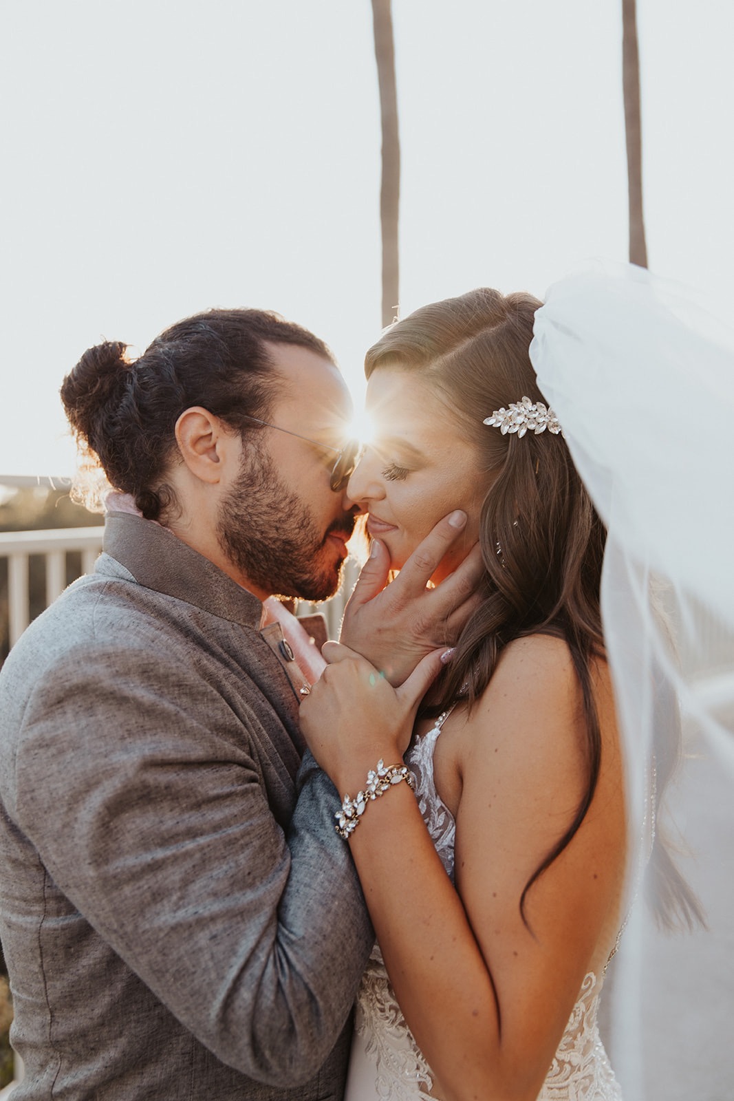 Erica and Patrick kissing at sunset with palms behind them at Park Hyatt Aviara